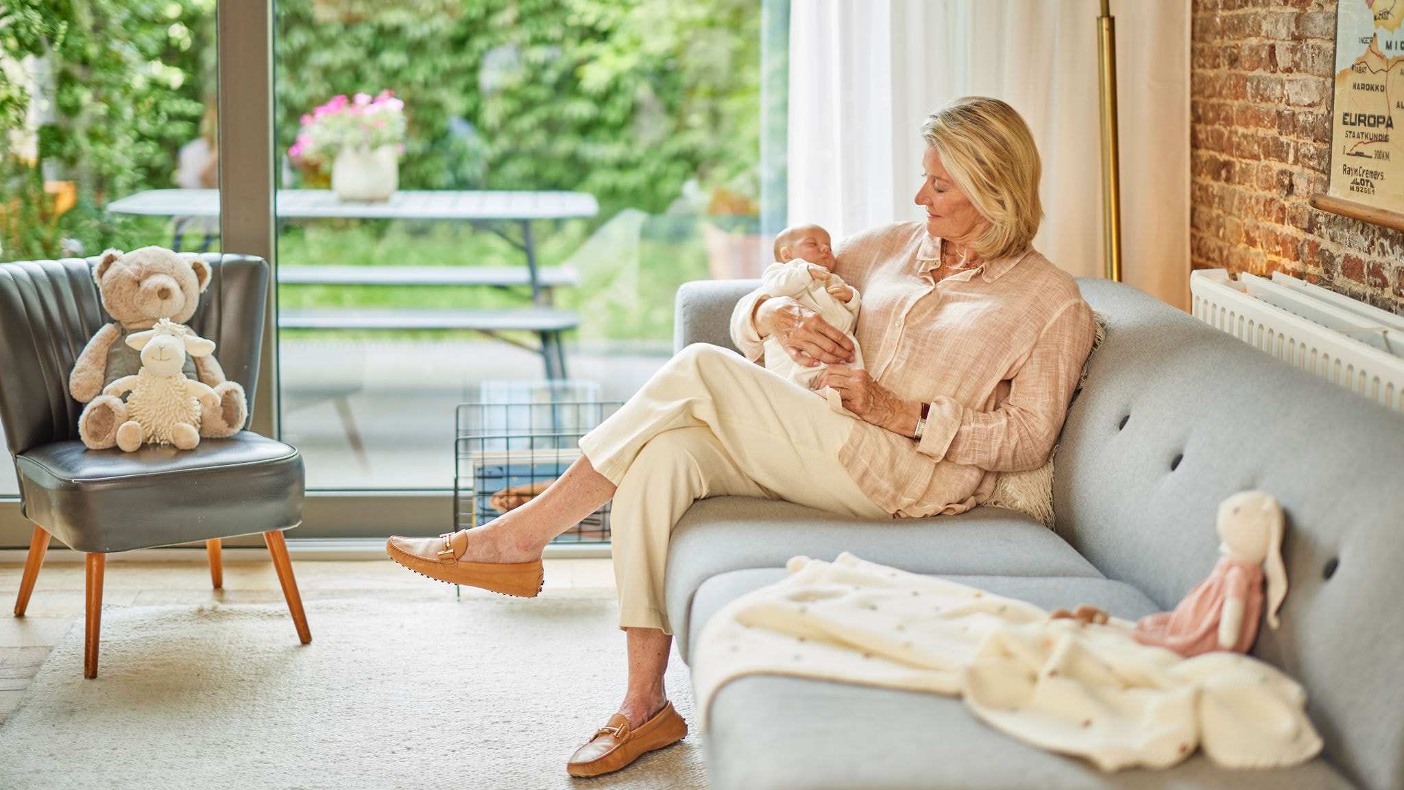 Señora sostiene a un bebé en una casa climatizada por suelo radiante Daikin Altherma