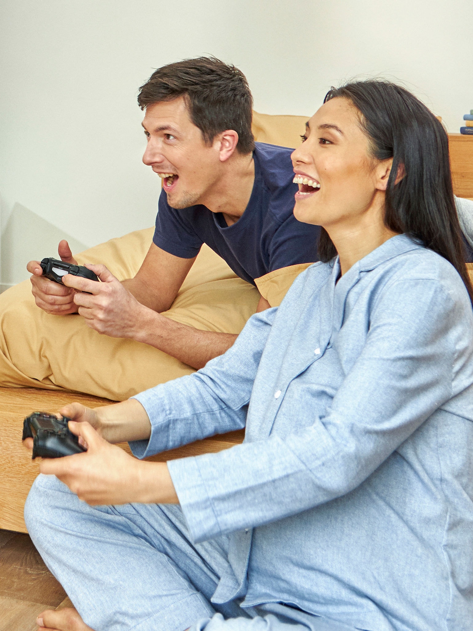 Una pareja embarazada disfruta jugando a un videojuego en su dormitorio
