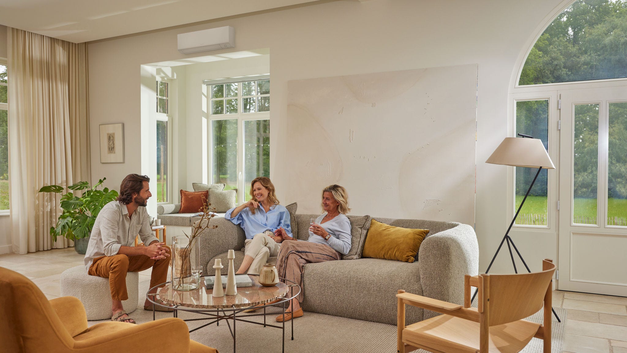 Familia descansando en el salón con un aire acondicionado de pared