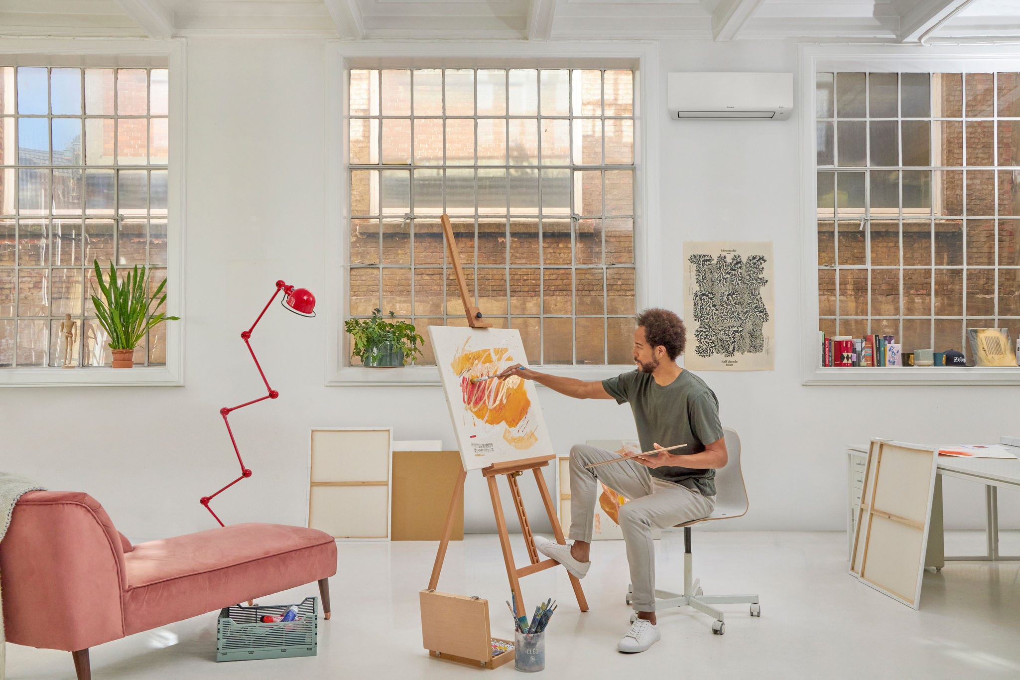 Hombre pintando en su taller climatizado por aire acondicionado de bajo consumo