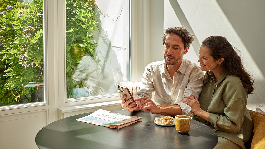 Pareja sentados mirando un móvil viendo los tipos de productos de Daikin