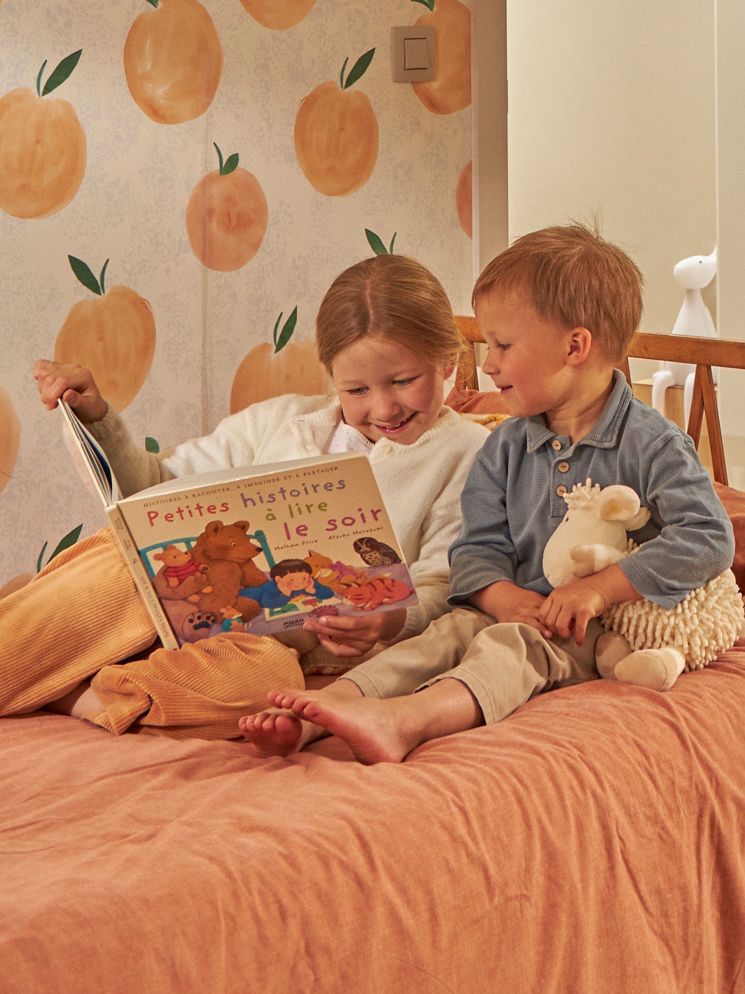 Niños leyendo un libro en la cama
