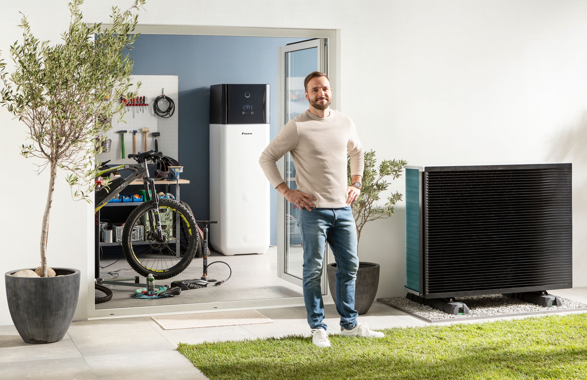 Hombre en su jardin frente a una unidad exterior de Daikin Altherma
