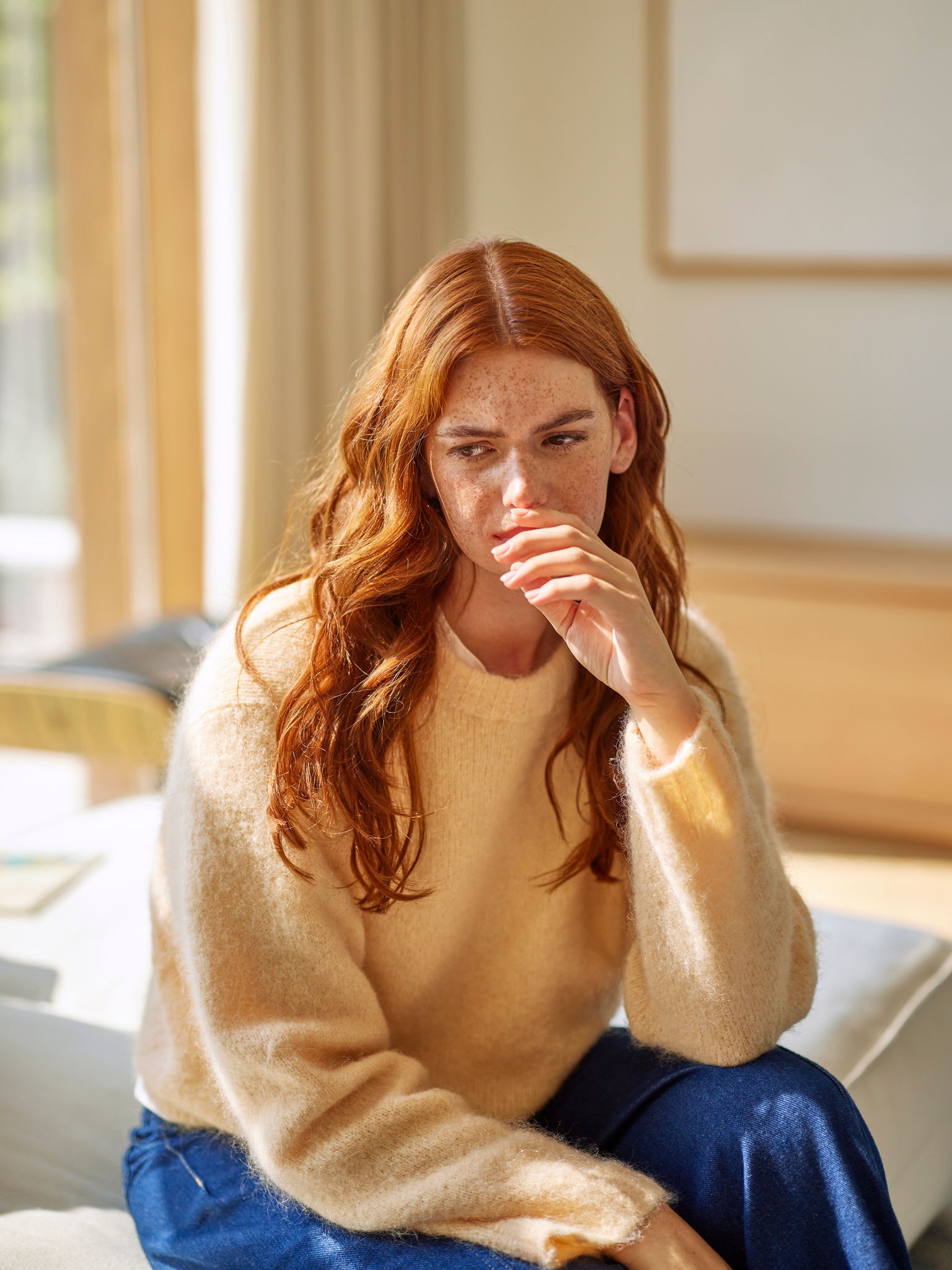 Mujer reaccionando a los desagradables olores de la cocina en la sala de estar