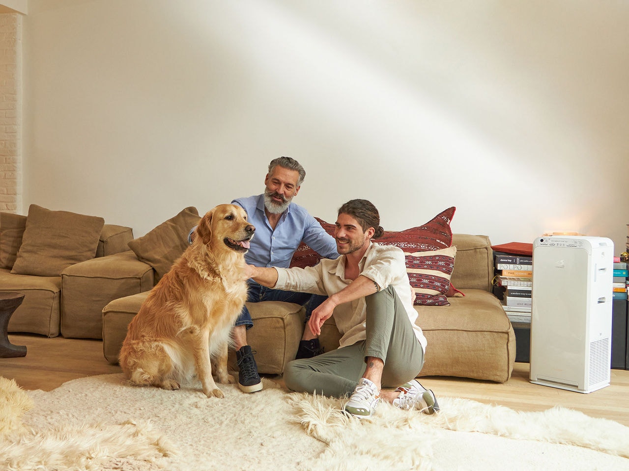 Padre e hijo acariciando a su perro en el salón de su casa
