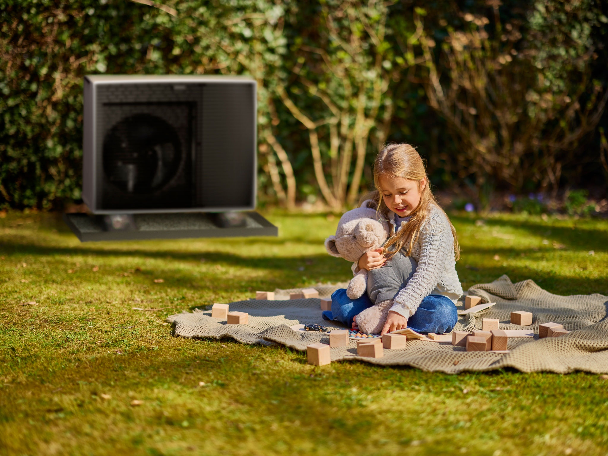 niña jugando junto a una unidad exterior de aerotermia