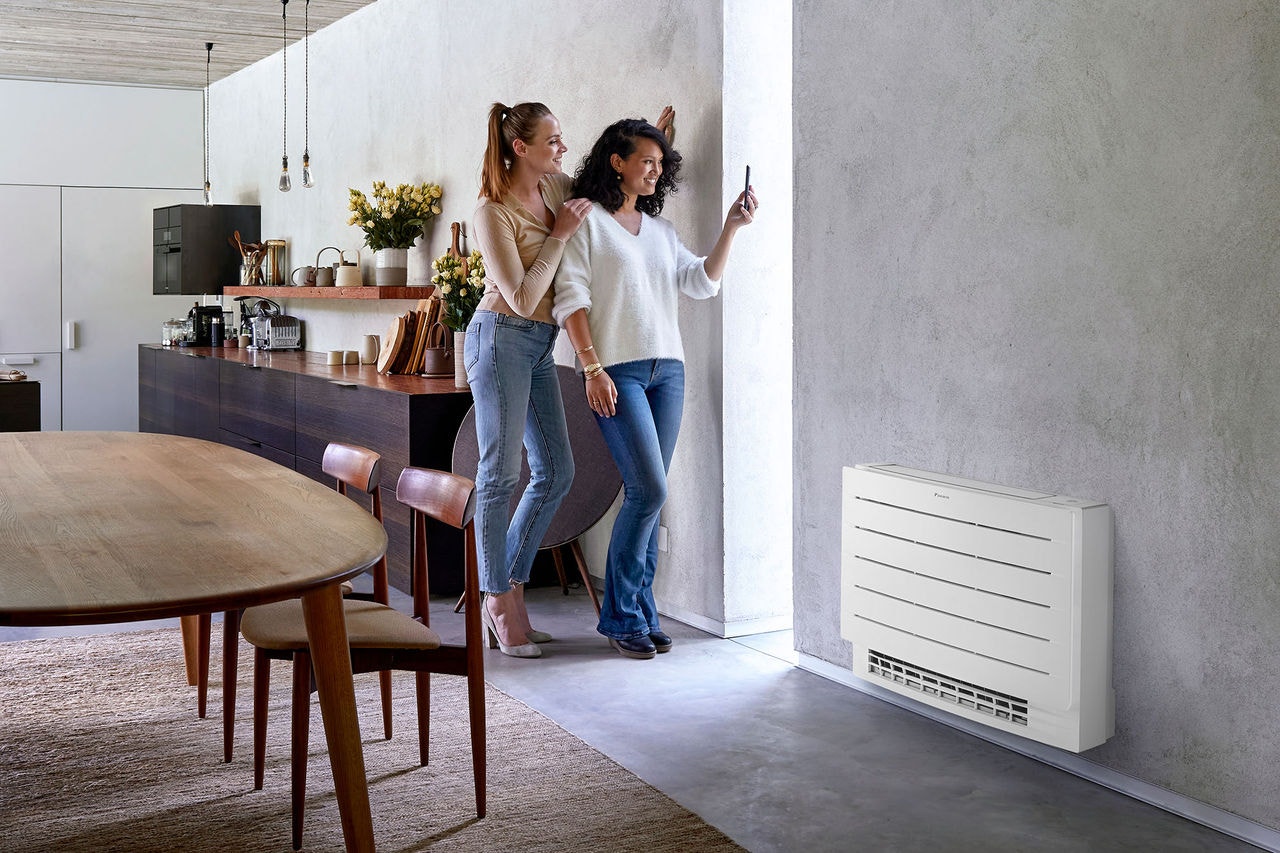 Mujeres tomándose una foto con el móvil en el comedor de su casa 