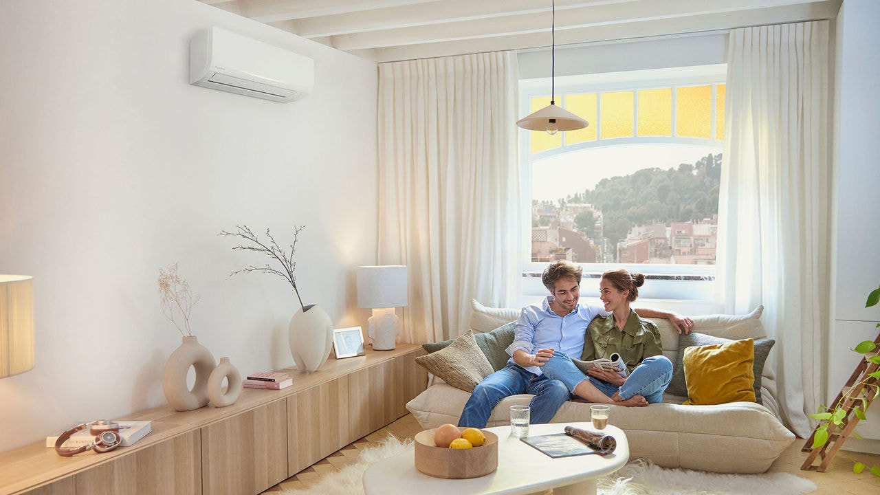 Pareja viendo una revista en el sofa de su casa