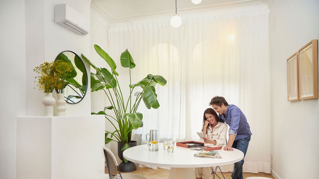 Pareja viendo fotografías en la mesa comedor de su hogar