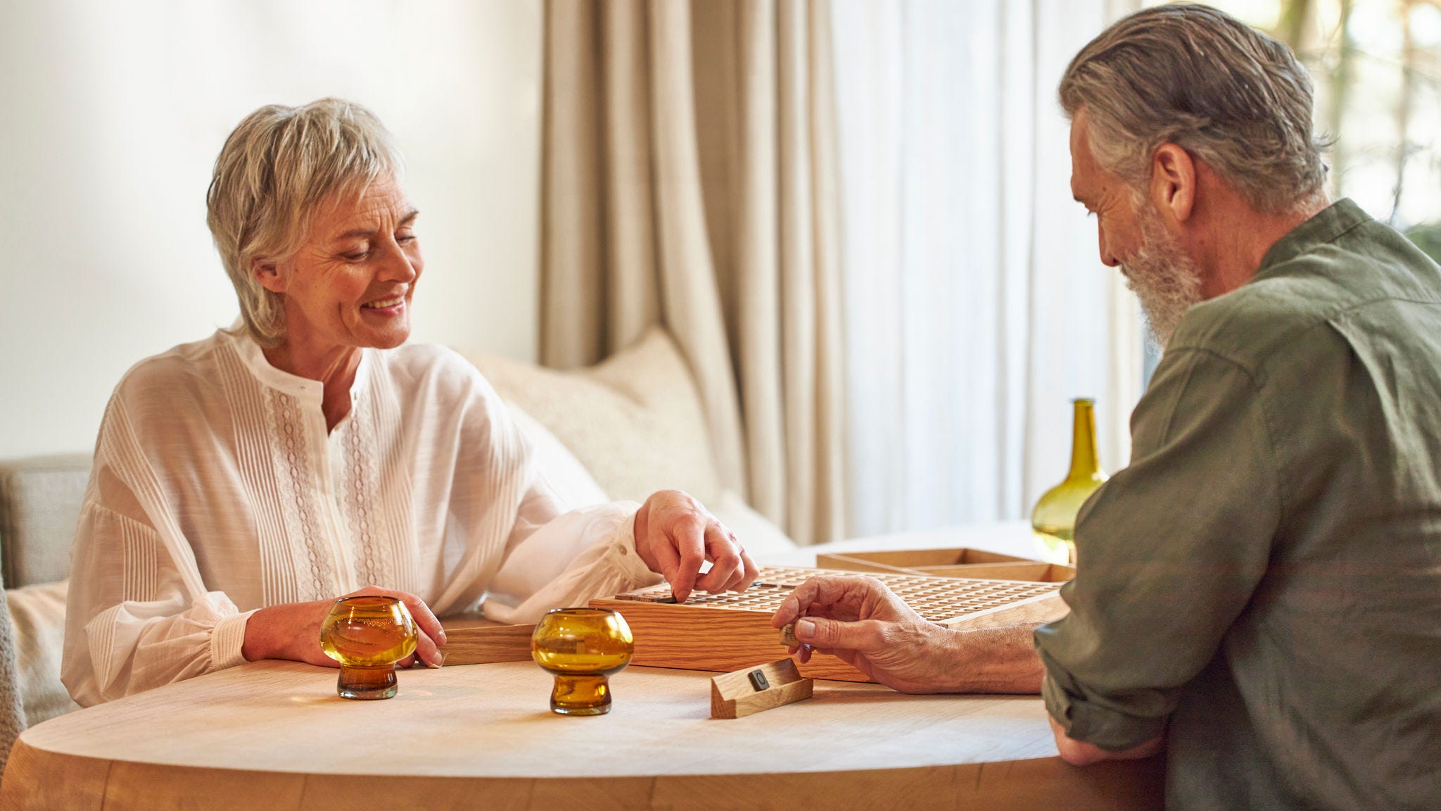Pareja jugando a juegos de mesa mientras disfruta de una temperatura ambiente perfecta