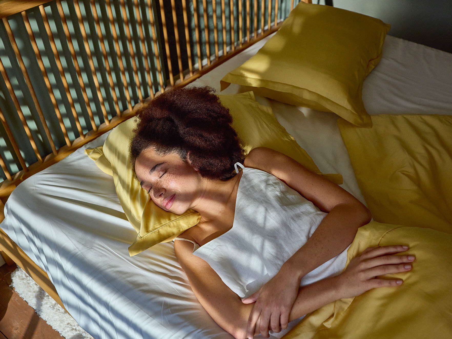 Mujer durmiendo en su cama con la luz del sol dandole en la cara