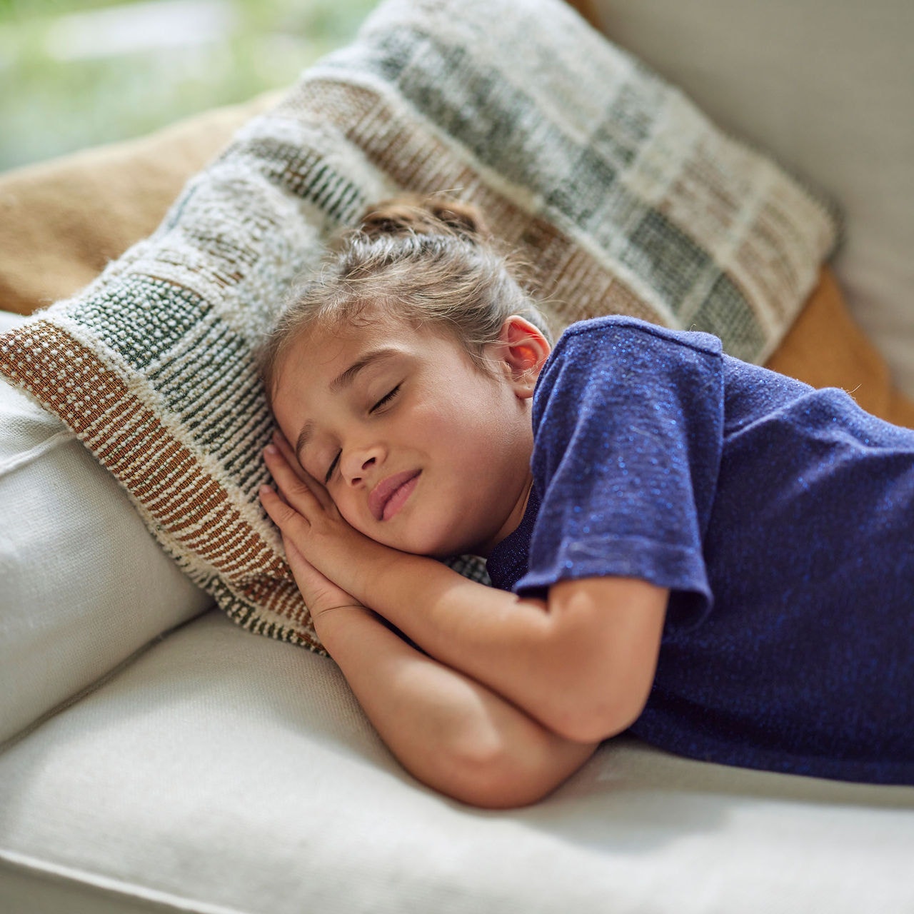 niña durmiendo en el sofá de su casa