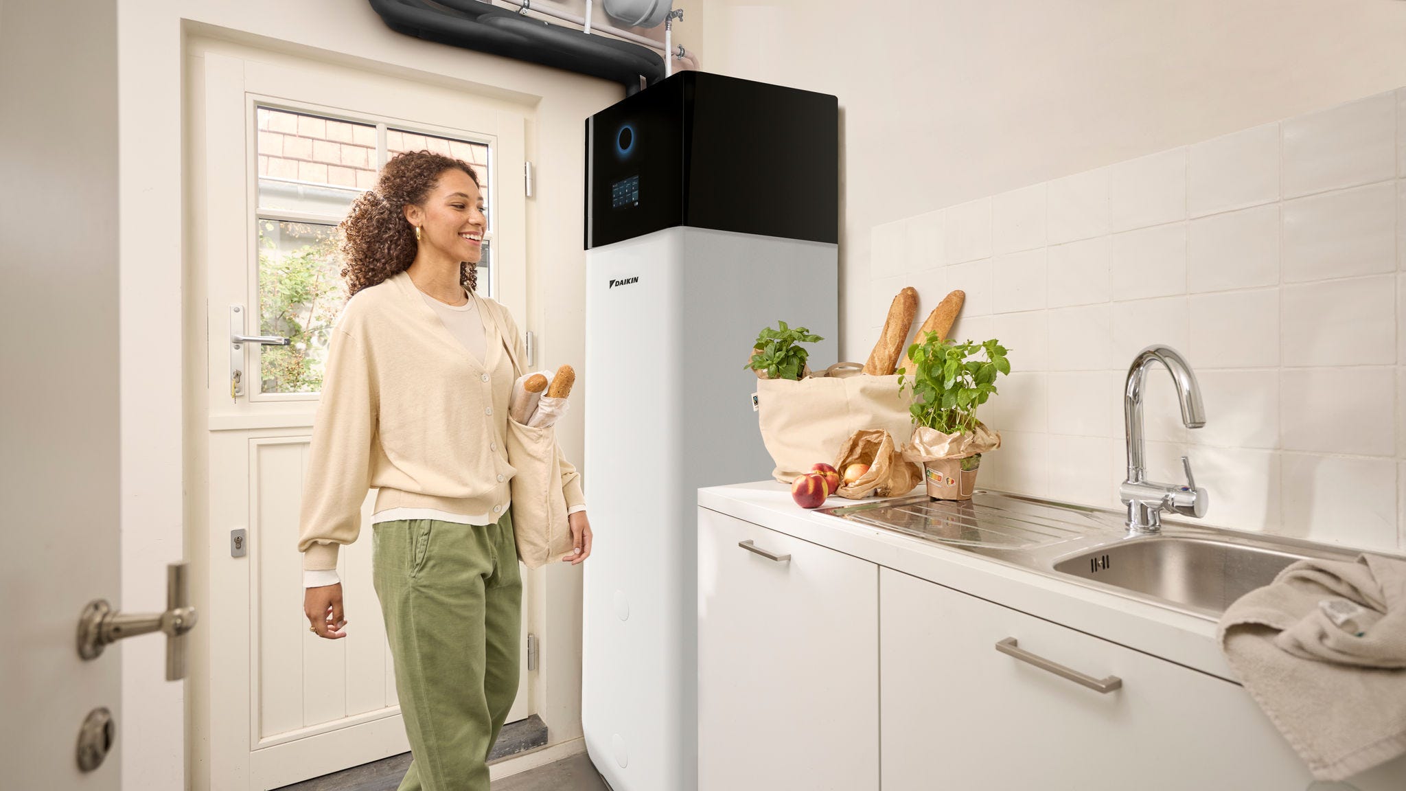 Mujer junto a una unidad interior de su equipo de aerotermia bibloc