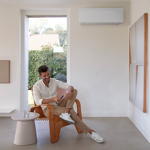 Hombre disfrutando del aire acondicionado que le proporciona la aerotermia de Daikin