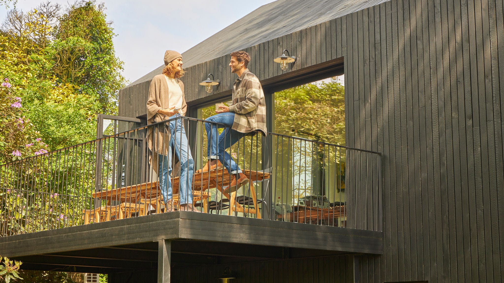 Pareja hablando en la terraza de un bungalow en plena naturaleza