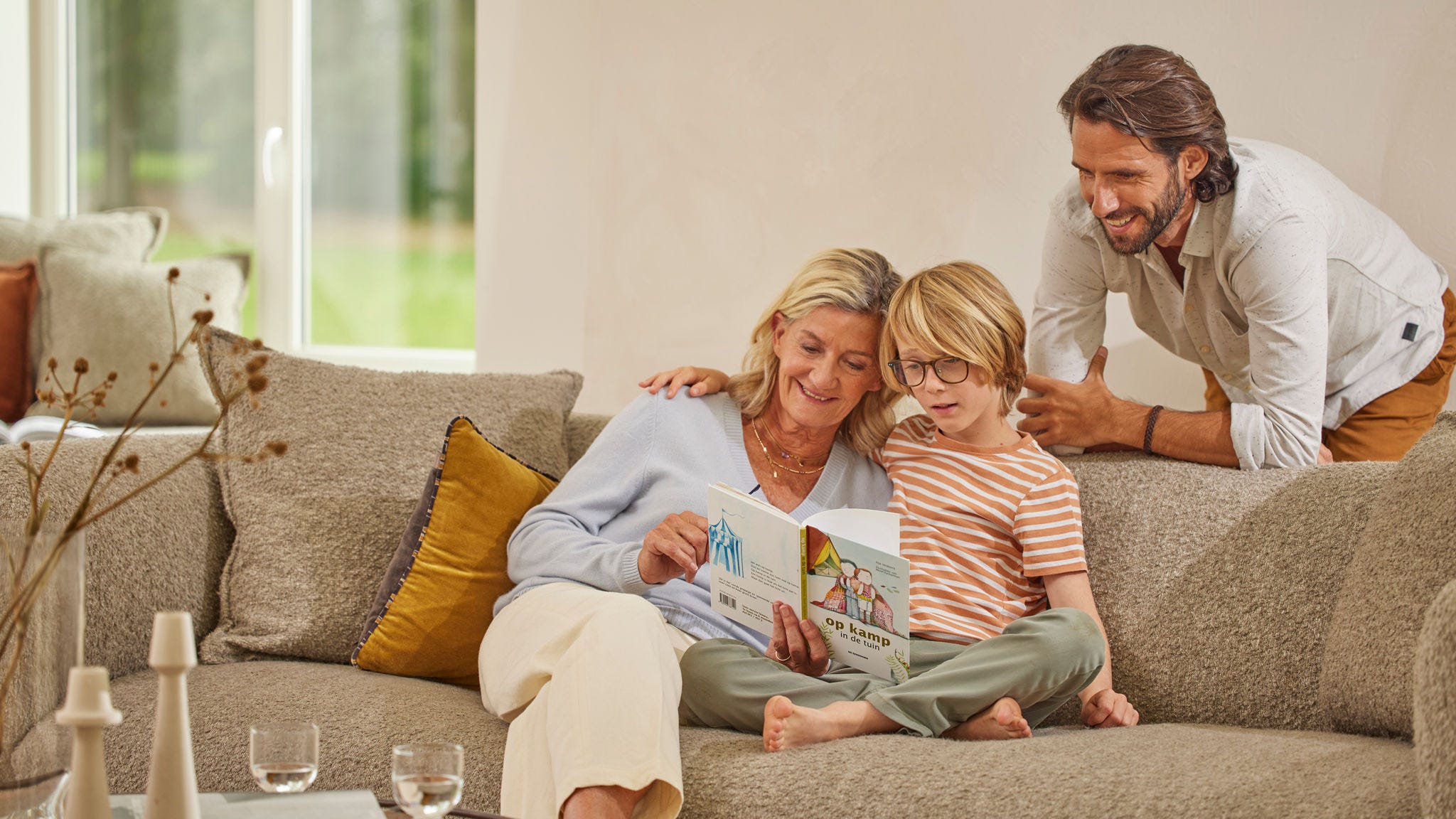 Familia disfruta de un cuento en el sofa de su casa con calefacción por aerotermia