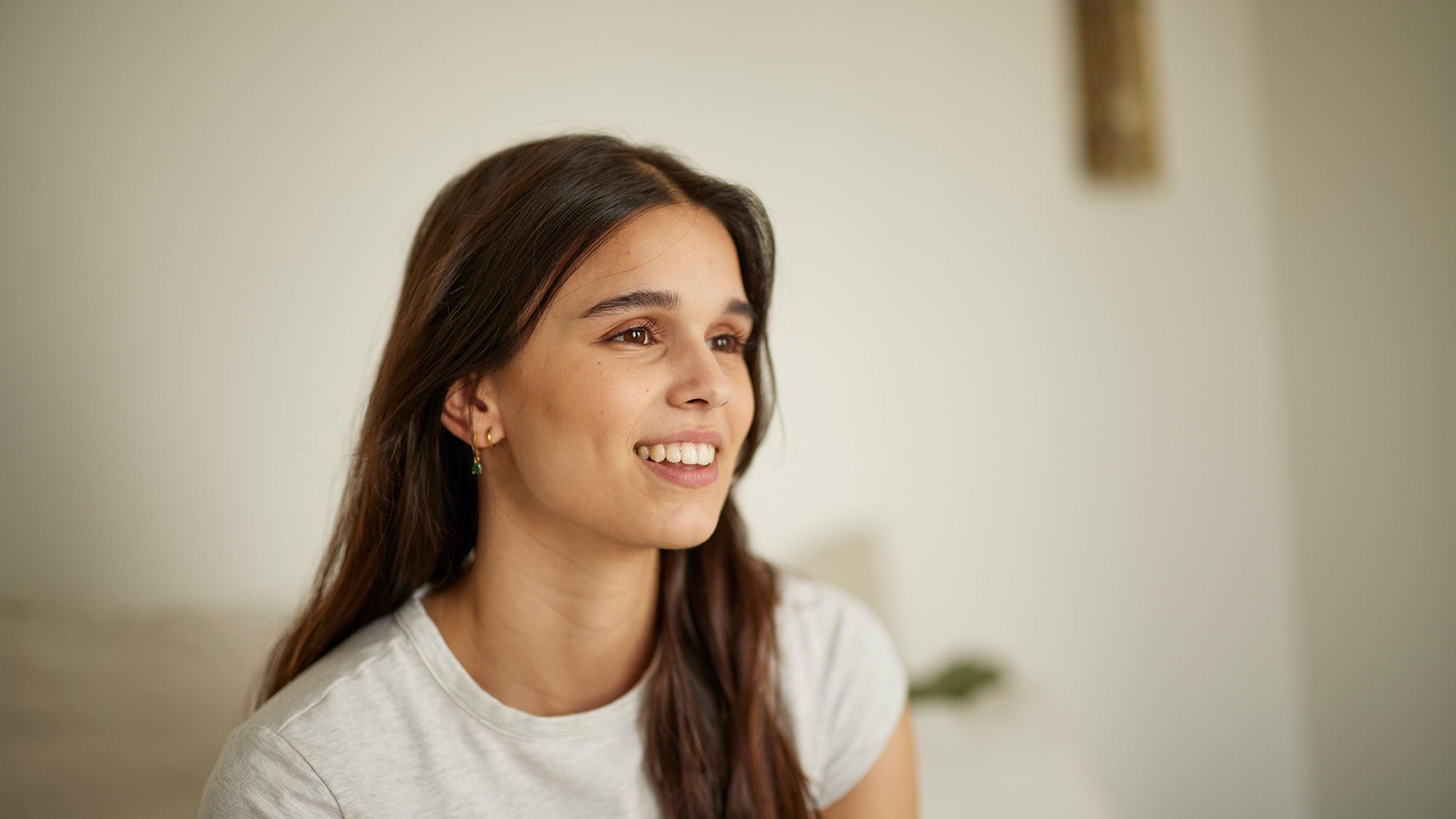 Chica sonriendo en el sofá de su casa