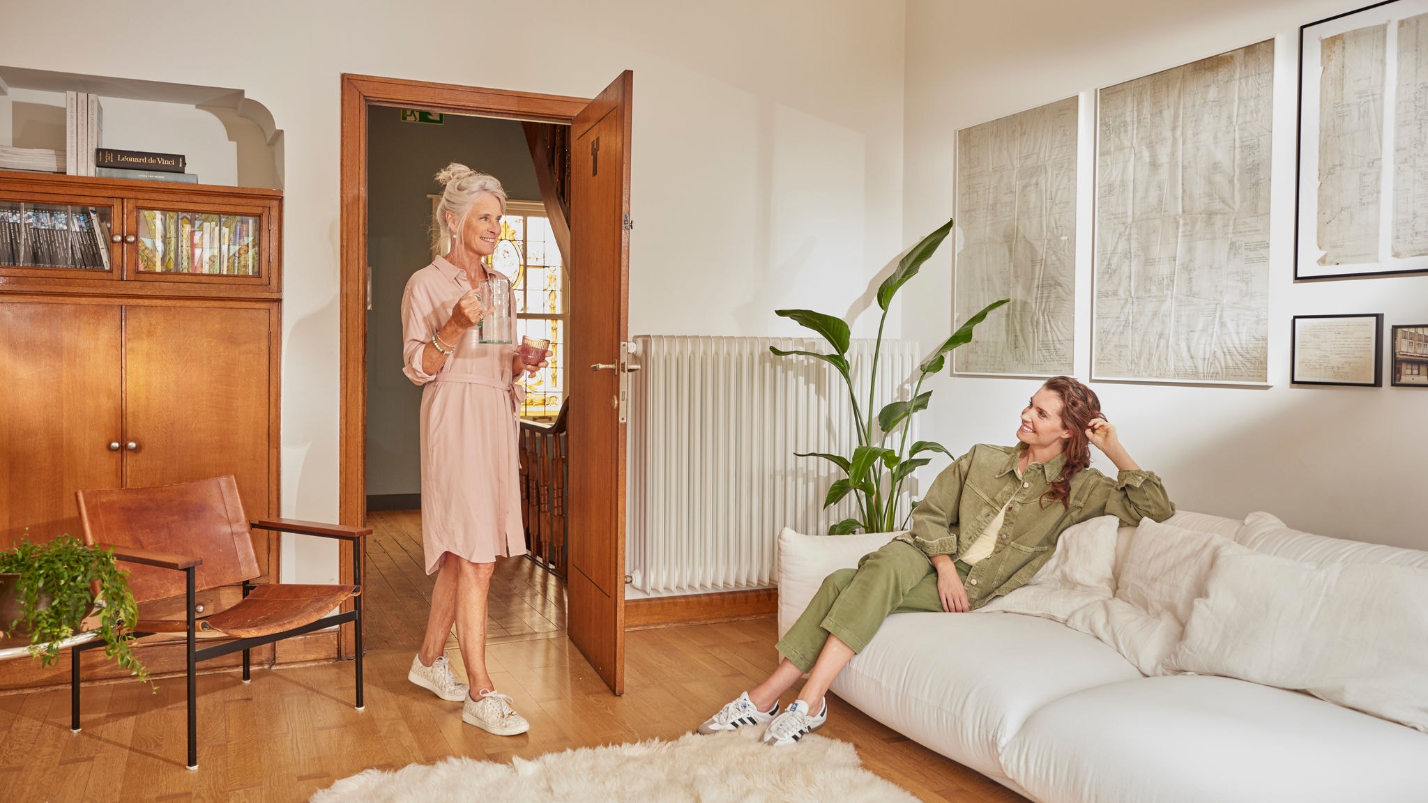 Mujer sirve un vaso de agua a otra mujer