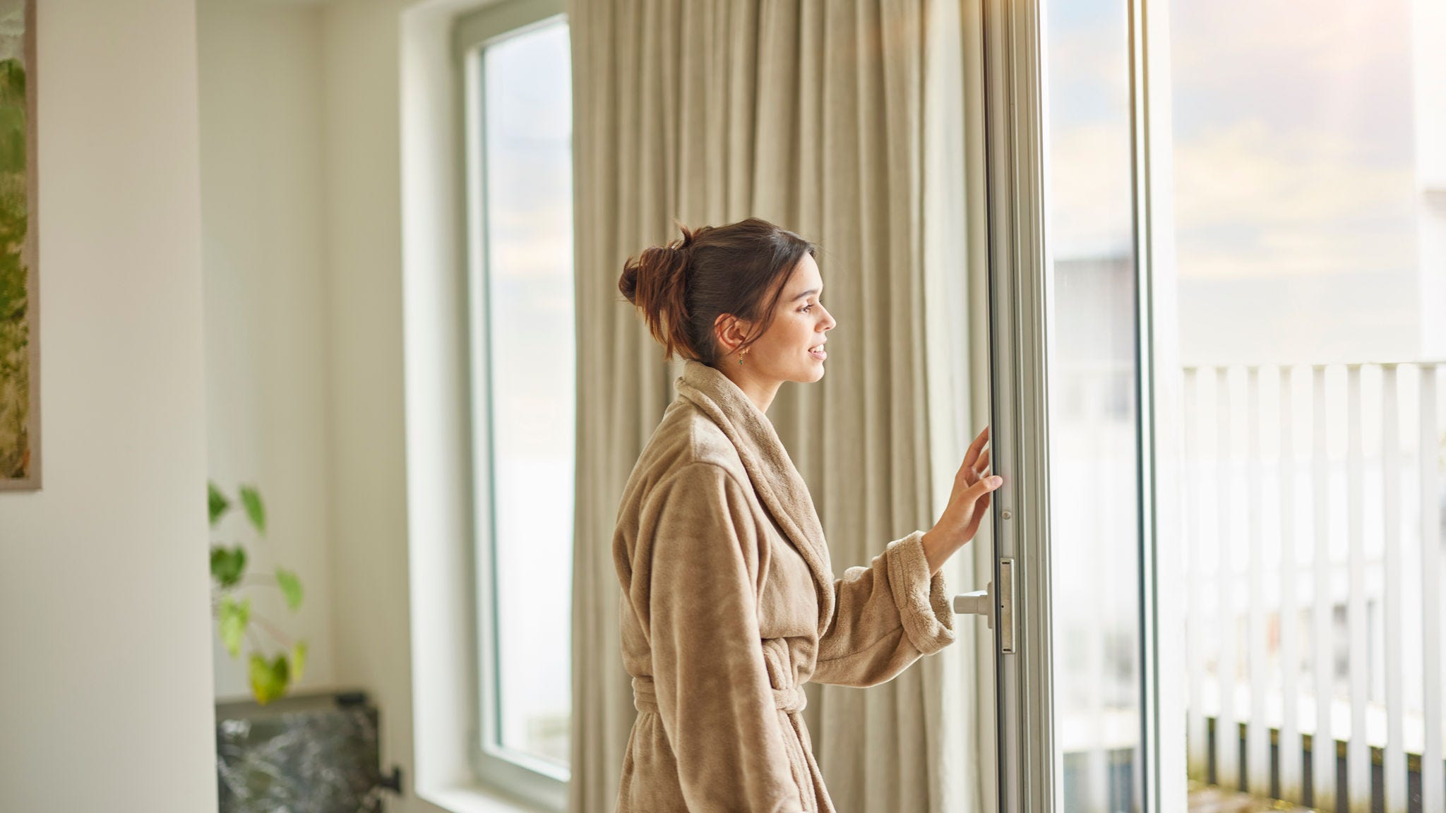 Mujer cerrando la ventana de su casa