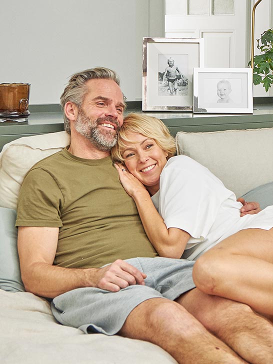 Hombre y mujer sentados en el sofá sonriendo