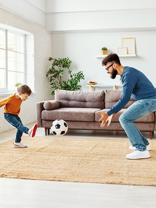 Padre e hijo disfrutando de la comodidad de la aerotermia en su hogar.
