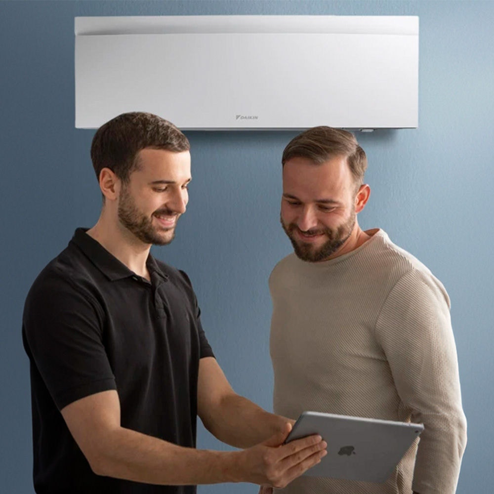 Instalador de Daikin explicando a un hombre el funcionamiento de los equipos Daikin