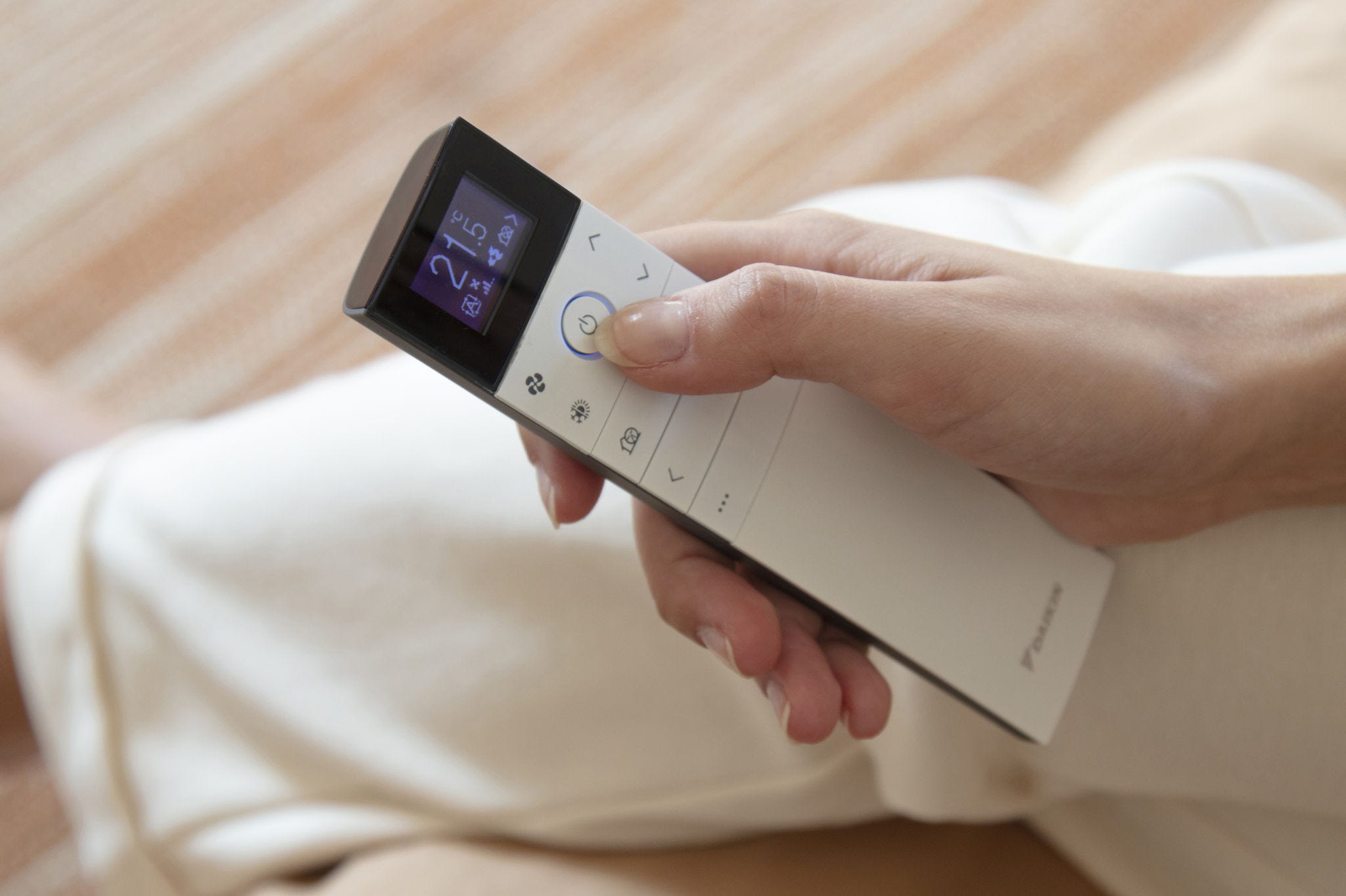 Mano sujentado un mando de aire acondicionado