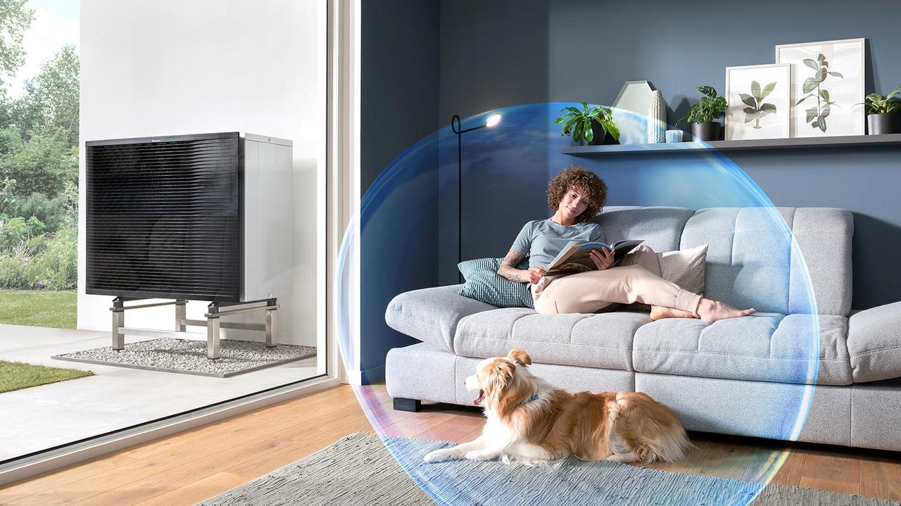 Una mujer y su perro descansando en el salón y disfrutando del clima perfecto que ofrece la aerotermia de Daikin