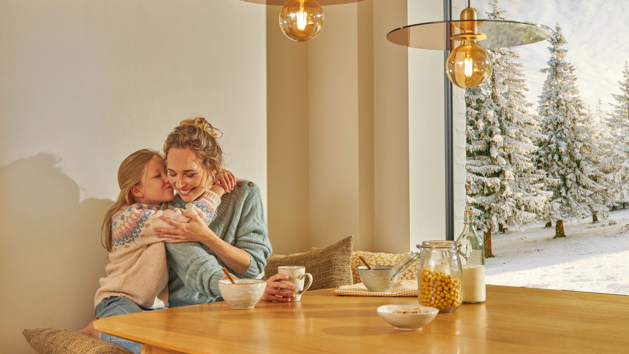 Madre e hija felices desayunando en su casa con aerotermia Daikin