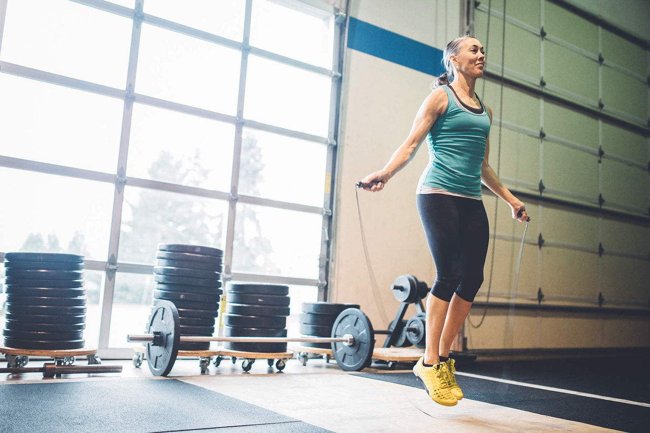 Mujer saltando a la comba en un gimnasio.