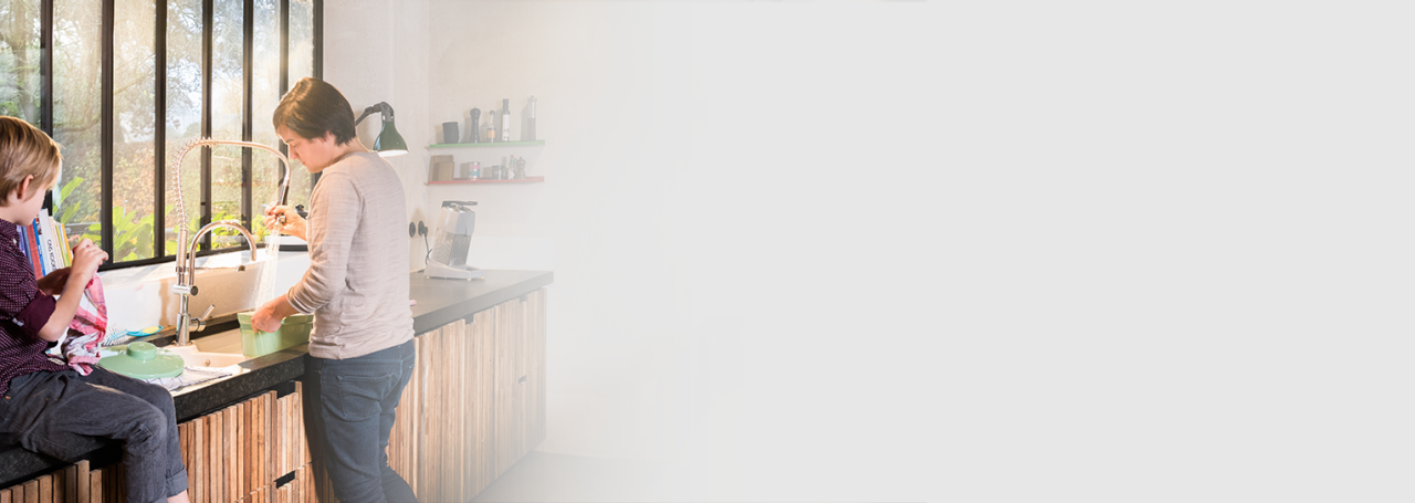 Mujer usando el grifo de agua caliente